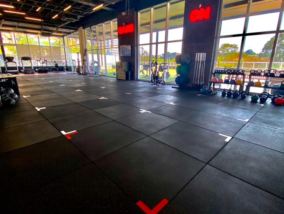 Área de treino da 4PERFORM com piso emborrachado, racks e luz natural